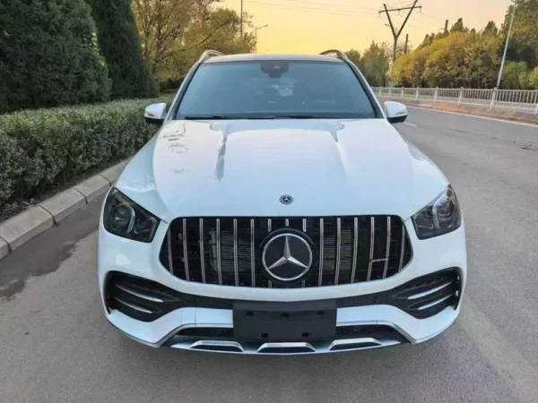 Mercedes-AMG GLE 53 4MATIC+ SUV 01 Performance-Driven Highlights (Rear View): Model Identification: Clearly badged as the "GLE 53" and "AMG", denoting its position as a performance-tuned model. AMG Exhaust System: Features a quad-outlet exhaust (four round tailpipes) integrated into the rear diffuser, which signifies the potent AMG-enhanced 3.0L inline-six turbo engine. This exhaust is known for its performance symphony, which can be conducted via AMG DYNAMIC SELECT. Sporty Rear Diffuser: The prominent lower rear valance/diffuser adds an aggressive, aerodynamic look, typical of AMG's styling cues. Modern LED Taillights: Equipped with sleek LED taillamps for a sophisticated, modern light signature and superior visibility. SUV Utility: Features a power liftgate and ample cargo capacity behind the rear seats, providing the necessary practicality of an SUV